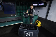 Clubhouse attendant Tyler Danburg packs the New York Yankees' helmets after the team's baseball game against the Cleveland Guardians was postponed Friday, July 1, 2022, in Cleveland. (AP Photo/Ron Schwane)