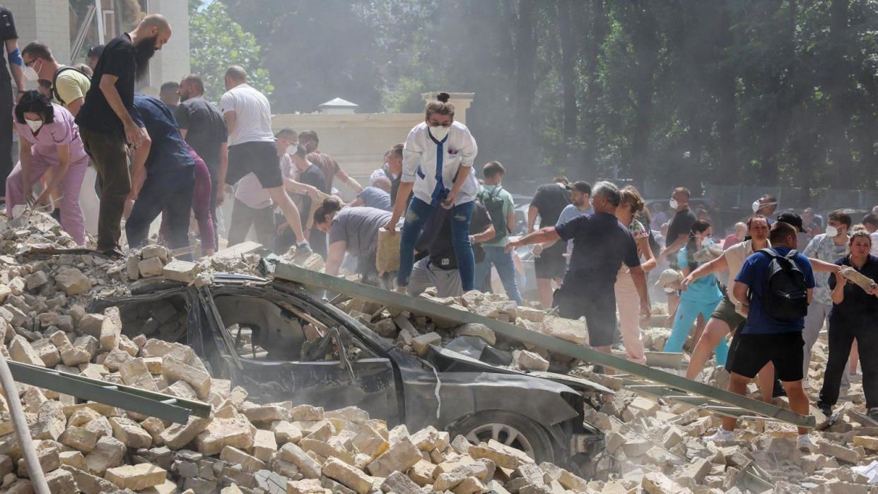 Hospital personnel and volunteers form a human chain to clear the rubble at Kyiv's Ohmatdyt's children's hospital after a missile strike blamed on Russia. Photo: 8 July 2024