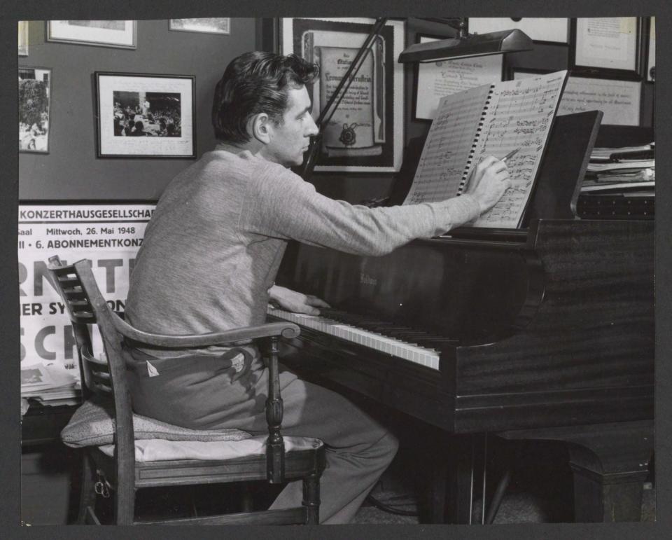 Leonard Bernstein working on a score at his piano in 1956.