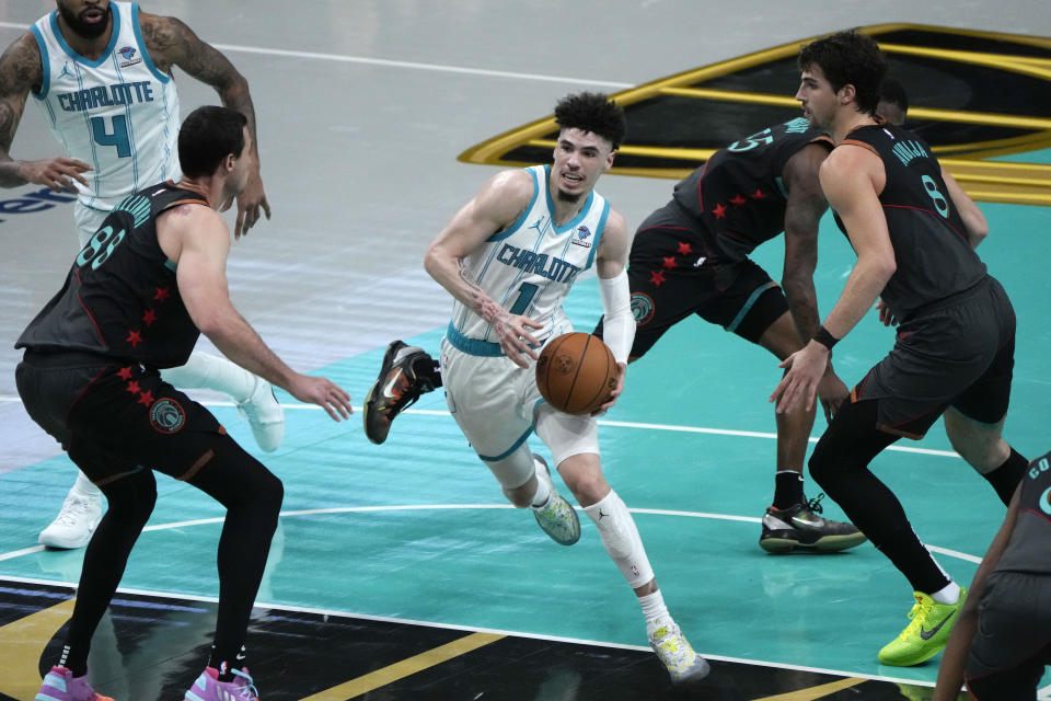 Charlotte Hornets guard LaMelo Ball (1) drives to the basket between Washington Wizards forwards Danilo Gallinari, left, and Deni Avdija, right, during the first half of an NBA basketball game Friday, Nov. 10, 2023, in Washington. (AP Photo/Mark Schiefelbein)