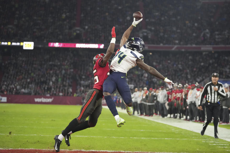 Seattle Seahawks' DK Metcalf (14) is defended by Tampa Bay Buccaneers' Jamel Dean (35) during the second half of an NFL football game, Sunday, Nov. 13, 2022, in Munich, Germany. The pass was incomplete. (AP Photo/Matthias Schrader)
