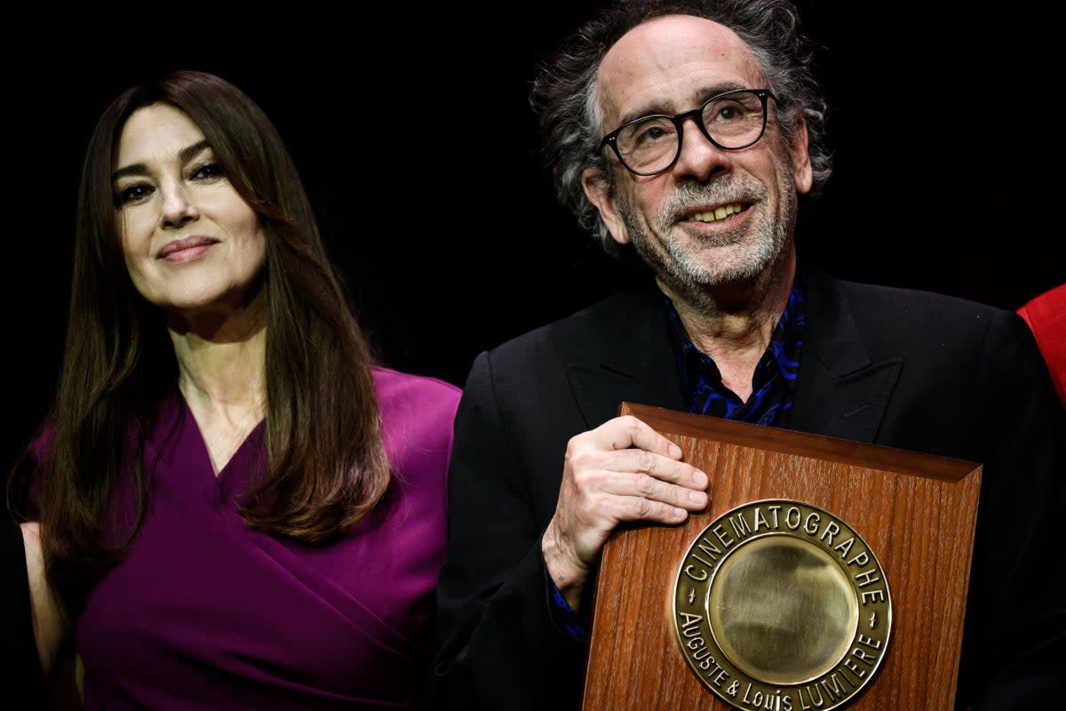Tim Burton reacts as he receives the Lumiere Award from Italian actress Monica Bellucci during the award ceremony of the 14th edition of the Lumiere Film Festival in Lyon, central-eastern France, on October 21, 2022 (AFP via Getty Images)
