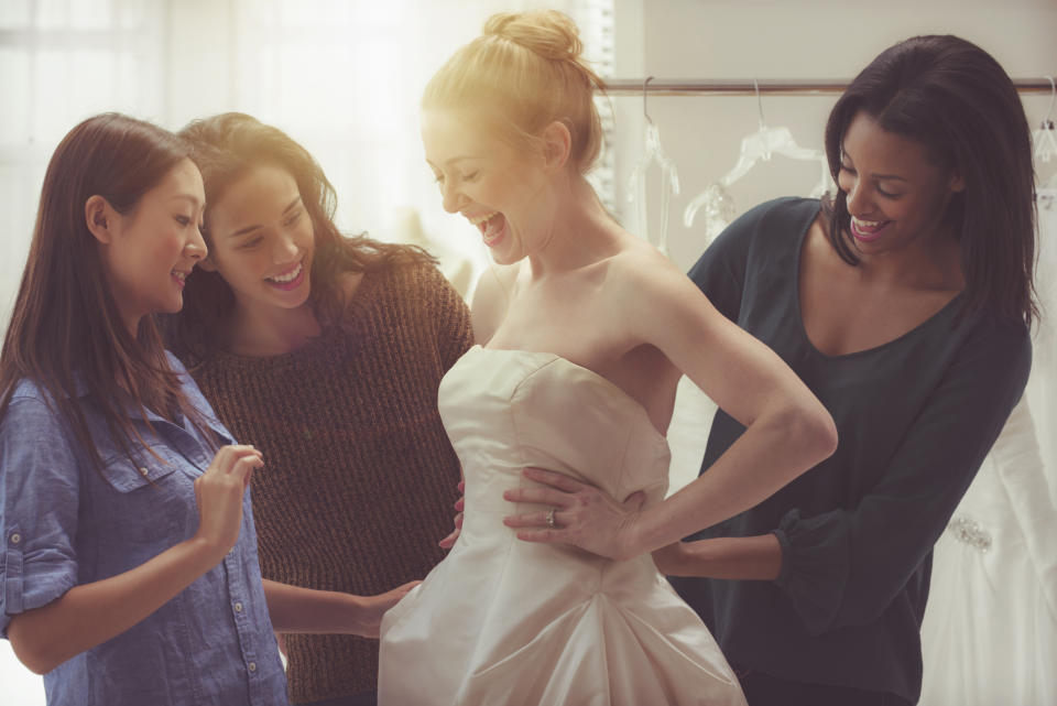 Bride and friends shopping for wedding gown