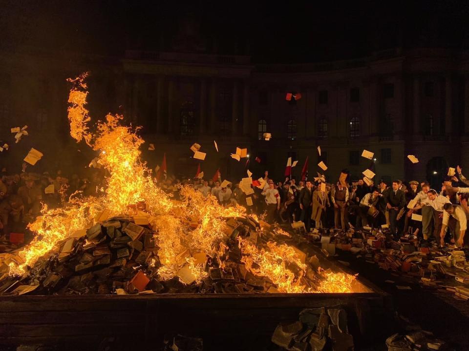 Germans throw books by Jewish author on a raging firest in a scene from Origin. 