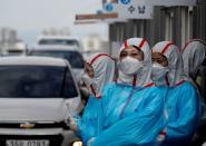 FILE PHOTO: Medical staff in protective gear work at a 'drive-thru' testing center for the novel coronavirus disease of COVID-19 in Yeungnam University Medical Center in Daegu