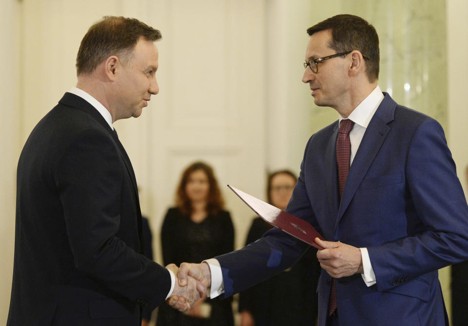 FILE - Polish President Andrzej Duda, left, designates then Finance Minister Mateusz Morawiecki, right, for the prime minister's post, in Warsaw, Poland, Friday, Dec. 8, 2017. Poland’s president Duda has tapped the outgoing prime minister, Mateusz Morawiecki of the Law and Justice party, to try to form the country’s next government. His decision is expected to delay the establishment of a functioning government because a majority of lawmakers aren't likely to give Morawiecki approval for his proposed Cabinet. (AP Photo/Alik Keplicz), File)