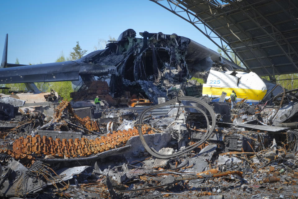 The gutted remains of the Antonov An-225, world's biggest cargo aircraft, surrounded by Russian military vehicles destroyed during fighting between Russian and Ukrainian forces, at the Antonov airport in Hostomel, on the outskirts of Kyiv, Ukraine, Thursday, May 5, 2022. (AP Photo/Efrem Lukatsky)