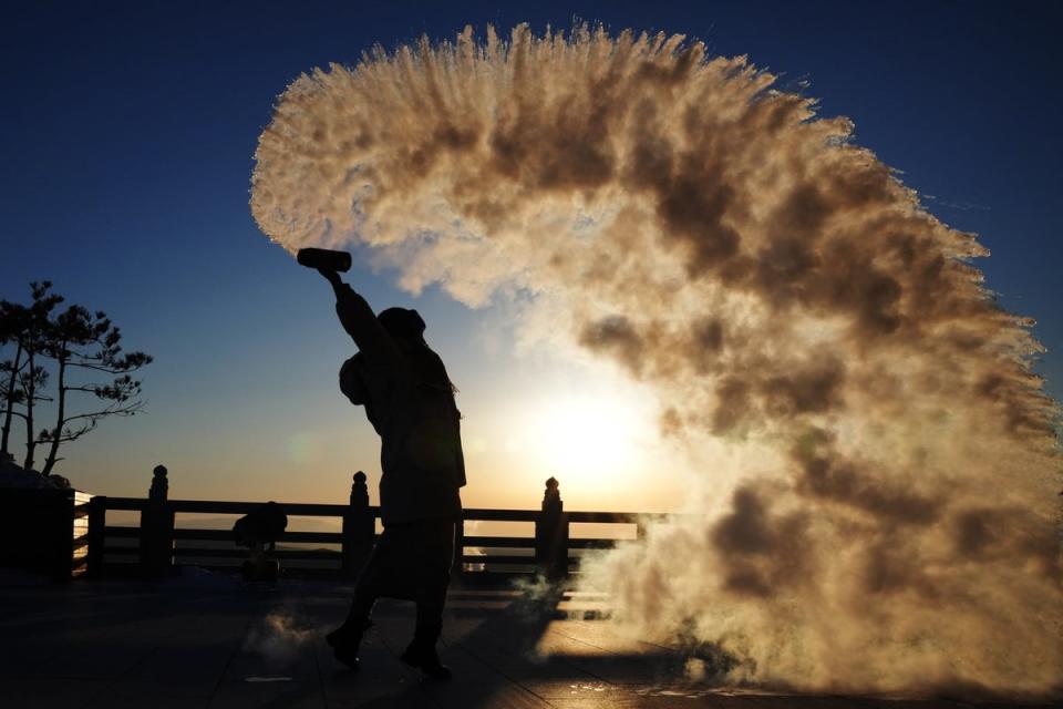A tourist pours water in the air last week in Heilongjiang Province, China, (EPA)