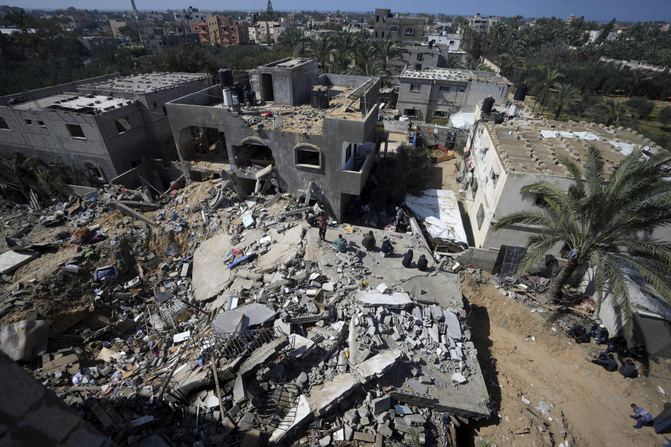 Palestinians look at destruction after an Israeli airstrike on a residential building of the Ganan family in Deir al Balah, Gaza Strip, Thursday, March 7, 2024. (AP Photo/Adel Hana)