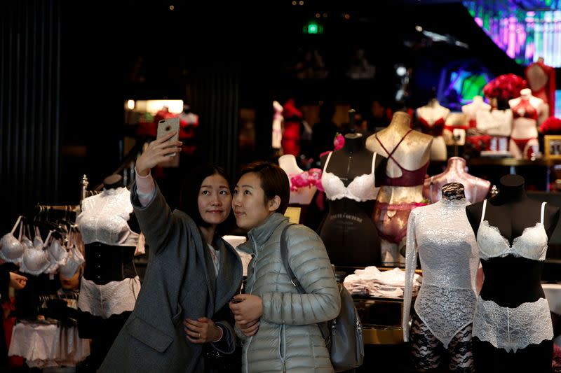 FILE PHOTO: Women take a selfie after the opening ceremony of the Victoria's Secret Shanghai Flagship Store in Shanghai,