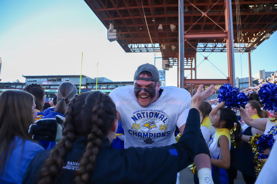 SDSU tackle Garret Greenfield hugs a fan after his team's win in the national championship game.