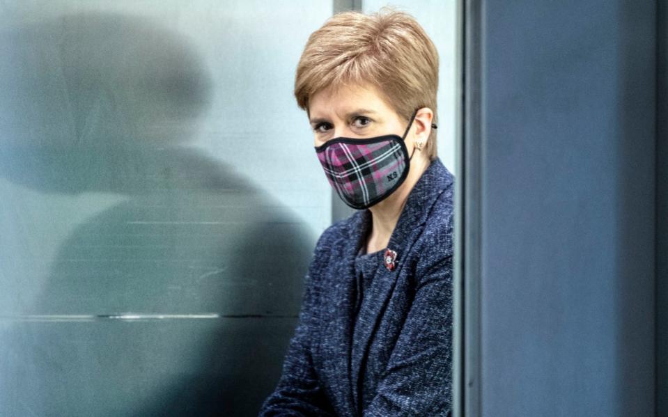 Nicola Sturgeon wearing a face mask arrives for the First Minister's Questions session at the Scottish Parliament - PA