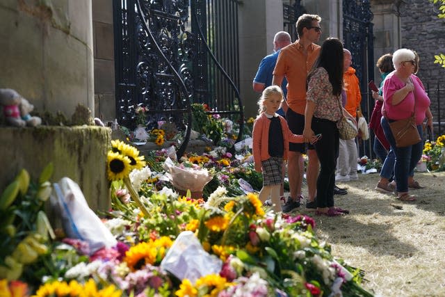 Members of the public view messages and flowers