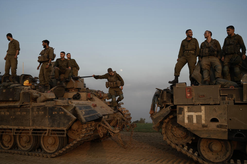 Israeli soldiers stand on top of armoured personnel carriers (APC) near the Israeli-Gaza border, in southern Israel, Monday, Dec. 25, 2023. The army is battling Palestinian militants across Gaza in the war ignited by Hamas' Oct. 7 attack into Israel. (AP Photo/Leo Correa)