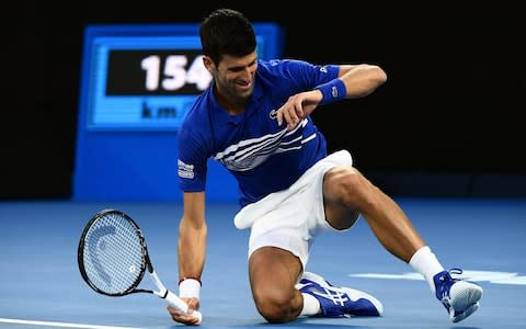 Serbia's Novak Djokovic falls on the ground as he plays against France's Lucas Pouille during their men's singles semi-final match on day 12 of the Australian Open tennis tournament in Melbourne on January 25, 2019. - Credit: AFP