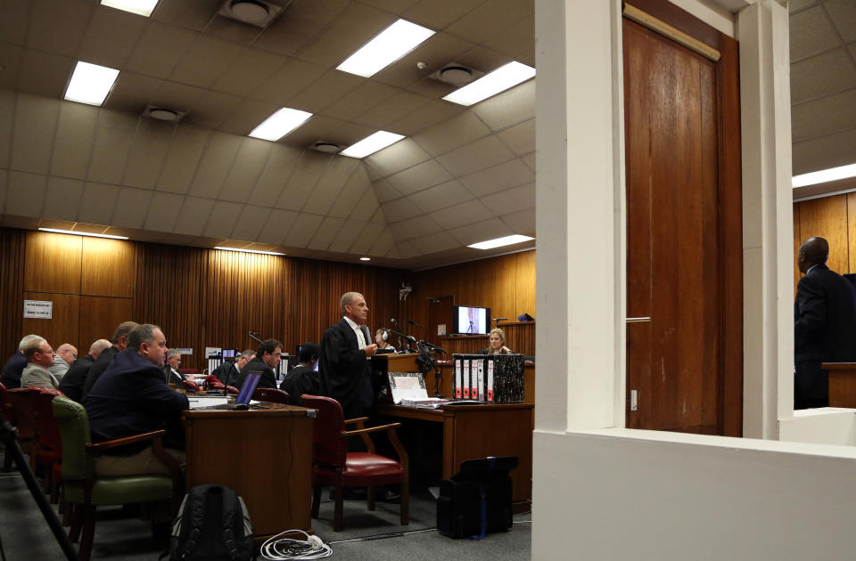 State prosecutor Gerrie Nel, middle, questions a ballistics police officer in the witness box captain Christiaan Mangena, far right, during the Oscar Pistorius trial at the high court in Pretoria, South Africa, Wednesday, March 19, 2014. Pistorius is charged with shooting dead his girlfriend, Reeva Steenkamp, through the door, exhibitted in court foreground, on Valentines Day in 2013. (AP Photo/Themba Hadebe, Pool)