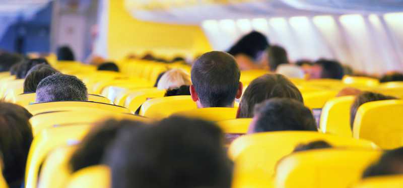 The inside of an airplane with passengers in the seats