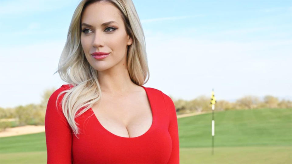 Paige Spiranac is seen here standing on the green of a golf course.