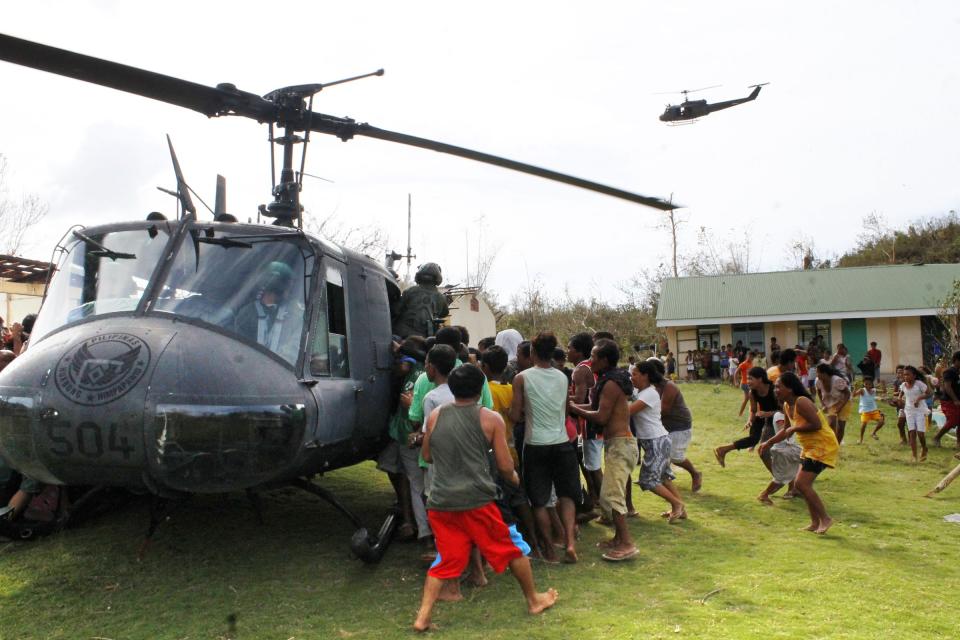 Residents rush to get food packs during a relief distribution after super typhoon Haiyan hit Iloilo province