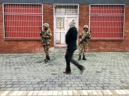 Soldiers patrol as they are deployed to quell gang violence in Manenberg township, Cape Town