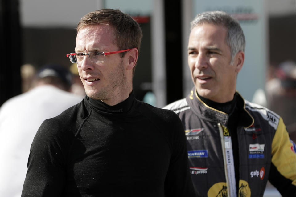 FILE - In this Friday, Jan. 3, 2020, file photo, Sebastien Bourdais, left, and Joao Barbosa walk back to their garage after a practice session during testing for the upcoming Rolex 24 hour auto race at Daytona International Speedway in Daytona Beach, Fla. Bourdais spent a day in early November helping IndyCar fine-tune its newest safety innovation. Later that night, he learned he was likely losing his job with a year remaining on his contract. (AP Photo/John Raoux, File)