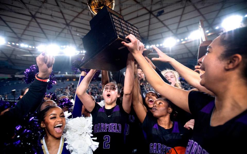 Garfield’s Katie Fiso hoists the state championship trophy after the Bulldogs defeated the Lake Washington Kangaroos, 58-49 in the 3A girls state championship game at the WIAA state basketball tournament in the Tacoma Dome in Tacoma, Washington, on Saturday, March 4, 2023.