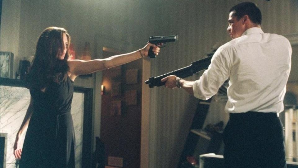 Angelina Jolie and Brad Pitt pointing guns at one another in the famous fight scene from the movie "Mr & Mrs Smith"