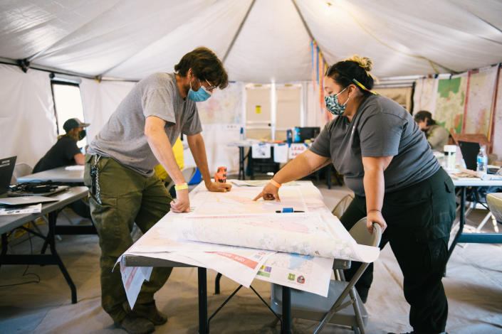 Vikki Preston, the Karuk tribal government representative on the Cronan Fire, and tribal fire line resource adviser Alex Watts-Tobinlook at a map at the fire camp in Etna, Calif. (Alexandra Hootnick for Yahoo News)