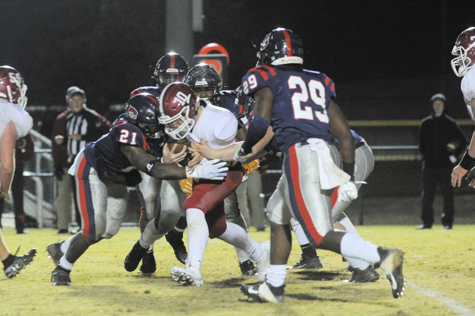 In this photo provided by Mike Pettus, Central of Clay County High School's J.D. McNealey (21) tackles a Sardis High School player during a football game in Lineville, Ala., Friday, Nov. 8, 2019. At Central of Clay County High School in Alabama, small-town football is thriving. The team has helped bond two communities that were once fierce rivals, then reluctant partners, and now proud supporters of a two-time Class 5A state football champions. (Mike Pettus via AP)