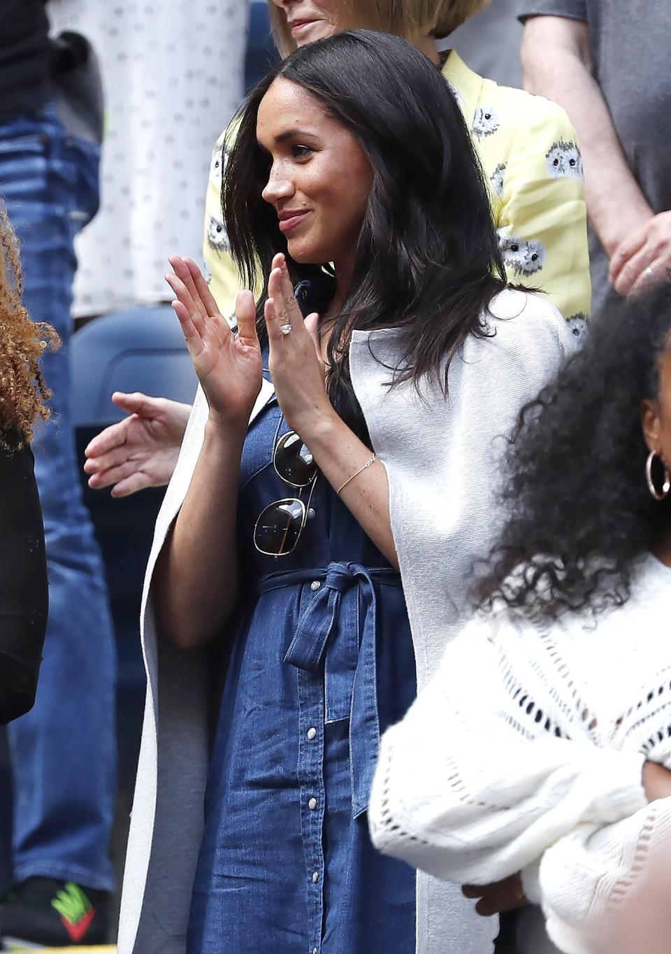 The Duchess of Sussex cheered on Williams dressed in a mid-length, button-down, denim dress with a tie belt from J. Crew.