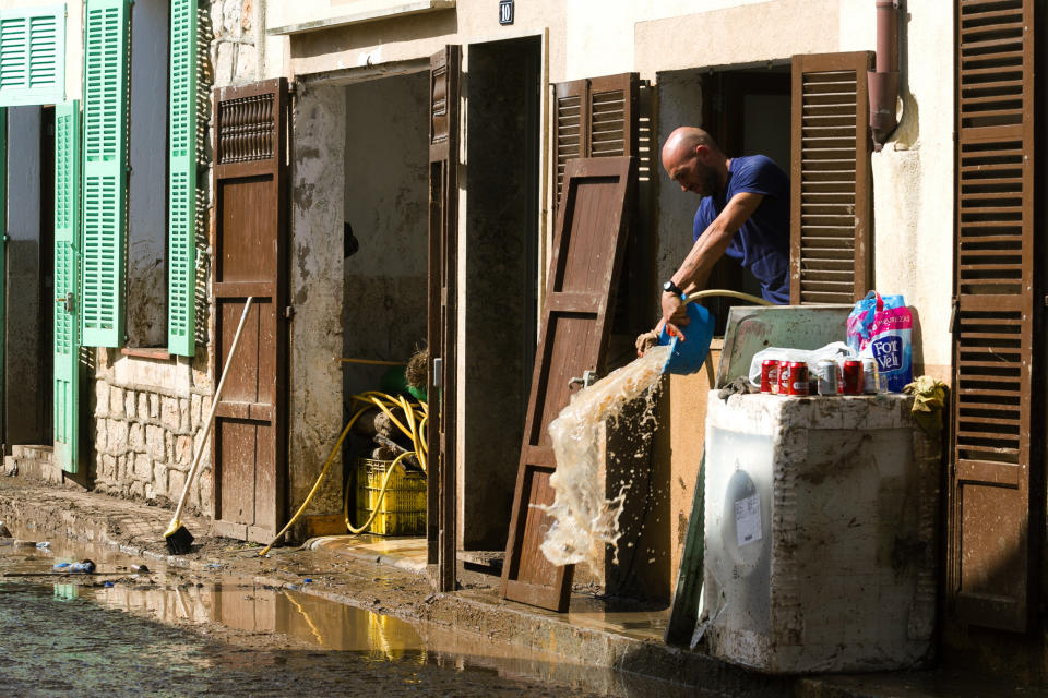 A man removes water and mud from his house affected by flooding in Sant Llorenc, Mallorca, Spain, on Thursday, Oct. 11, 2018. Spanish rescuers have found the bodies of a German couple that went missing after a destructive flash flooding that killed at least 10 more earlier this week in Mallorca and are still looking for a missing child. (AP Photo/Francisco Ubilla)