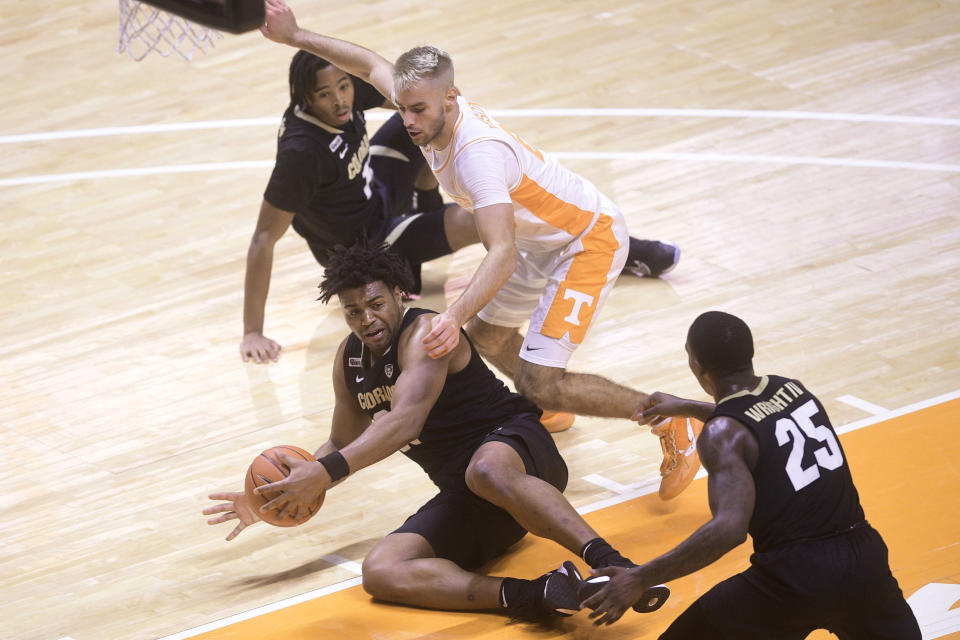 Colorado's Evan Battey (21) attempts to regain possession of the ball as Tennessee's Santiago Vescovi (25) defends during an NCAA college basketball game Tuesday, Dec. 8, 2020, in Knoxville, Tenn. (Caitie McMekin/Knoxville New-Sentinel via AP, Pool)