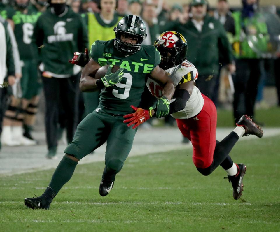 Michigan State Spartans running back Kenneth Walker III runs by Maryland Terrapins linebacker Ahmad McCullough during the first half Nov. 13, 2021 at Spartan Stadium.