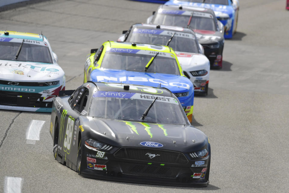 Riley Herbst (98) runs in third place while a group of cars follow close behind during a NASCAR Xfinity Series auto race at Richmond Raceway on Saturday, April 1, 2023, in Richmond, Va. (AP Photo/Mike Caudill)