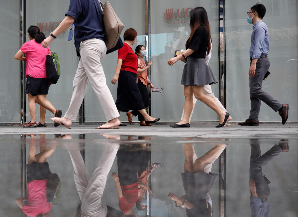 Office workers wearing protective face masks walk in Singapore's central business district, during the coronavirus disease (COVID-19) outbreak in Singapore, August 17, 2020.   REUTERS/Edgar Su