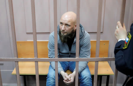 First Collection Bureau CEO Maxim Vladimirov, who was detained on suspicion of embezzlement, sits inside a defendants' cage as he attends a court hearing in Moscow, Russia February 15, 2019. REUTERS/Tatyana Makeyeva