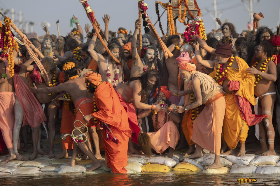 In this Jan. 15, 2019, photo, Hindu holy men from one of the ancient and most orthodox akharas "Juna akhara" take a dip on auspicious Makar Sankranti day during the Kumbh Mela festival in Prayagraj, Uttar Pradesh state, India. The Juna Akhara is the only monastic order to have accepted the newly formed Kinnar Akhara, led by transgender activist Laxmi Narayan Tripathi. Unlike other akharas, which are only open to Hindu men, Kinnar, founded in 2015, is open to all genders and religions. (AP Photo/Bernat Armangue)