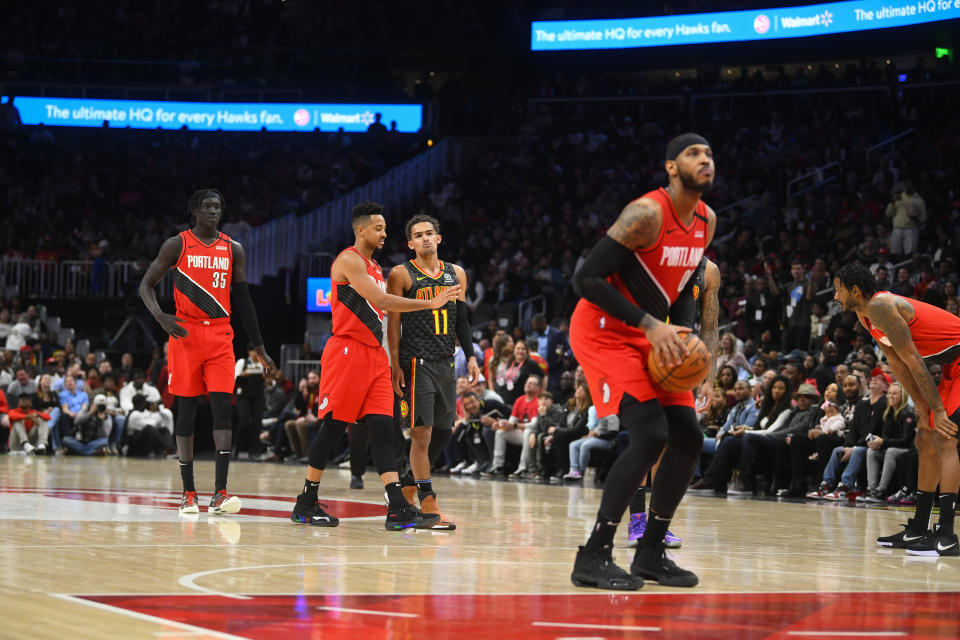 Portland Trail Blazers forward Carmelo Anthony looks to take a technical foul shot as teammate CJ McCollum (3) keeps Atlanta Hawks guard Trae Young (11) back during the second half of an NBA basketball game Saturday, Feb. 29, 2020, in Atlanta. (AP Photo/John Amis)