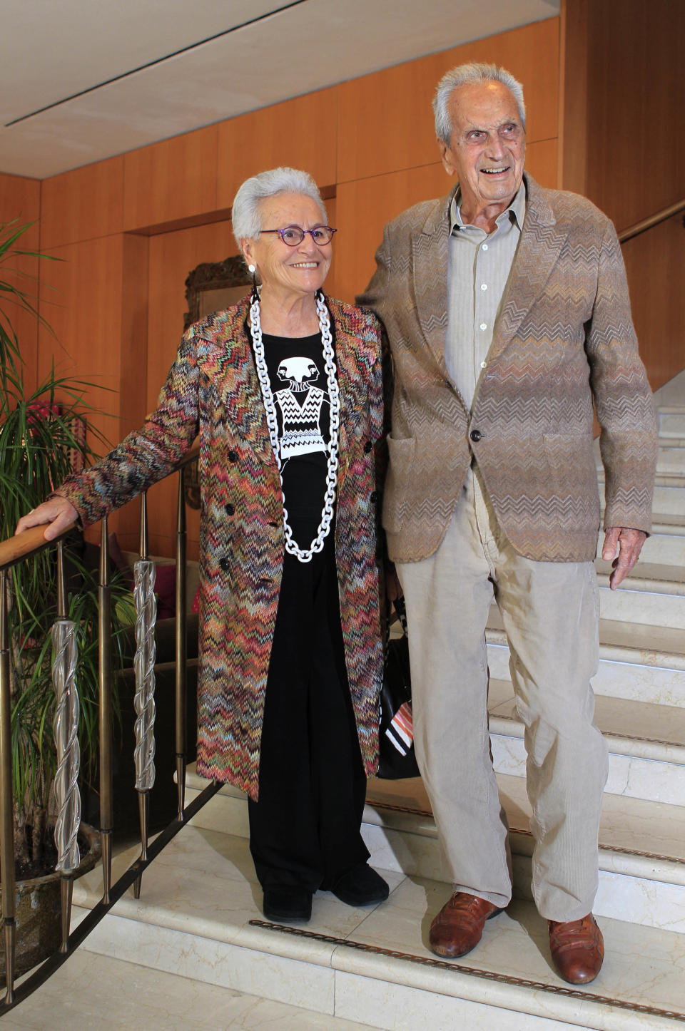 In this photo taken on March 22, 2012 Italian fashion designer Ottavio Missoni is flanked by his wife Rosita Jelimini in Milan, Italy. Italian fashion company Missoni says its co-founder, Ottavio Missoni, has died in his home earlier on Thursday, May 9, 2013 in northern Italy. Missoni, who was 92, founded the iconic fashion brand of zigzagged-patterned knitwear along with his wife, Rosita, in 1953. The Missonis are a family fashion dynasty, with the couple’s children and their offspring involved in expanding the brand. (AP Photo/Luca Bruno)