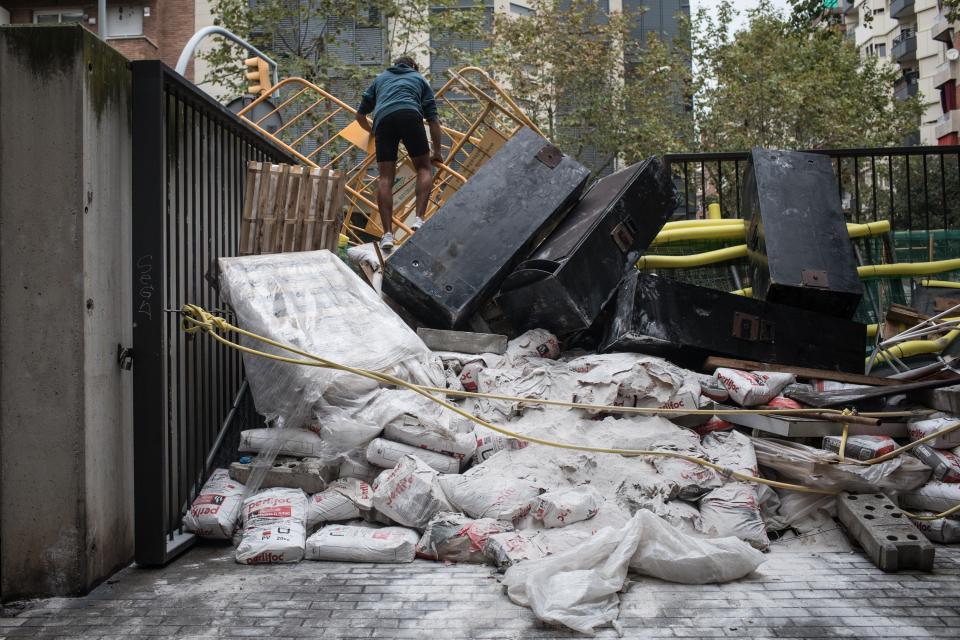 <p>A man looks out over a makeshift barricade protecting the back entrance of a school set up as a polling station. (Getty) </p>