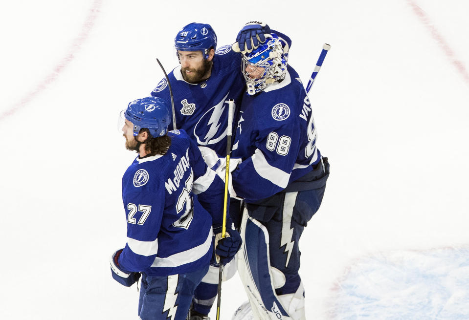 Tampa Bay Lightning goalie Andrei Vasilevskiy (88), Ryan McDonagh (27) and Barclay Goodrow (19) celebrate a win over the Dallas Stars in NHL Stanley Cup finals hockey action in Edmonton, Alberta, Monday, Sept. 21, 2020. (Jason Franson/The Canadian Press via AP)