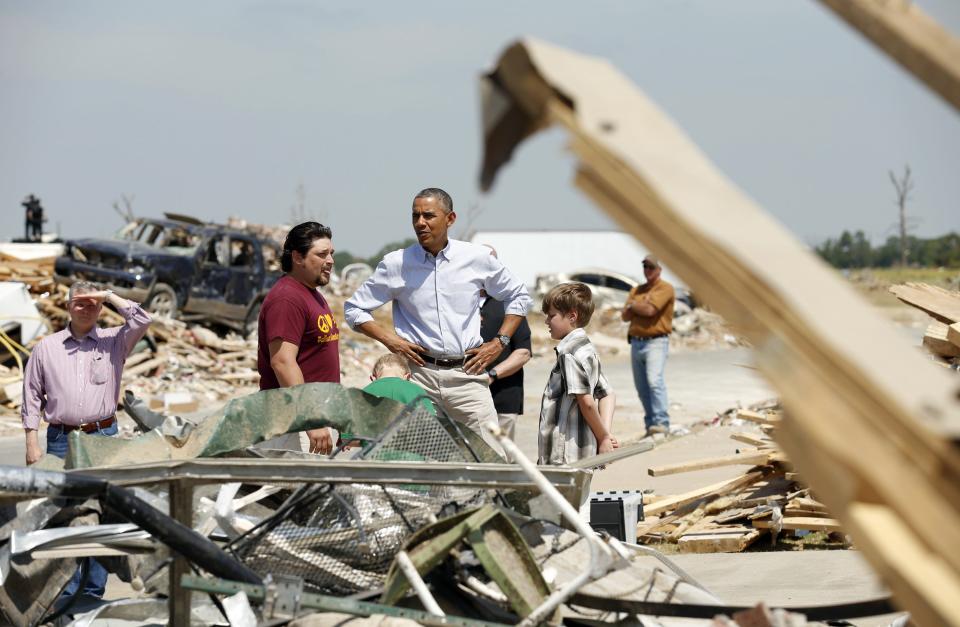 U.S. President Barack Obama talks with a family as he visits the tornado devastated town of Vilonia, Arkansas May 7, 2014. The tornadoes were part of a storm system that blew through the Southern and Midwestern United States earlier this week, killing at least 35 people, including 15 in Arkansas. Obama has already declared a major disaster in Arkansas and ordered federal aid to supplement state and local recovery efforts. (REUTERS/Kevin Lamarque)