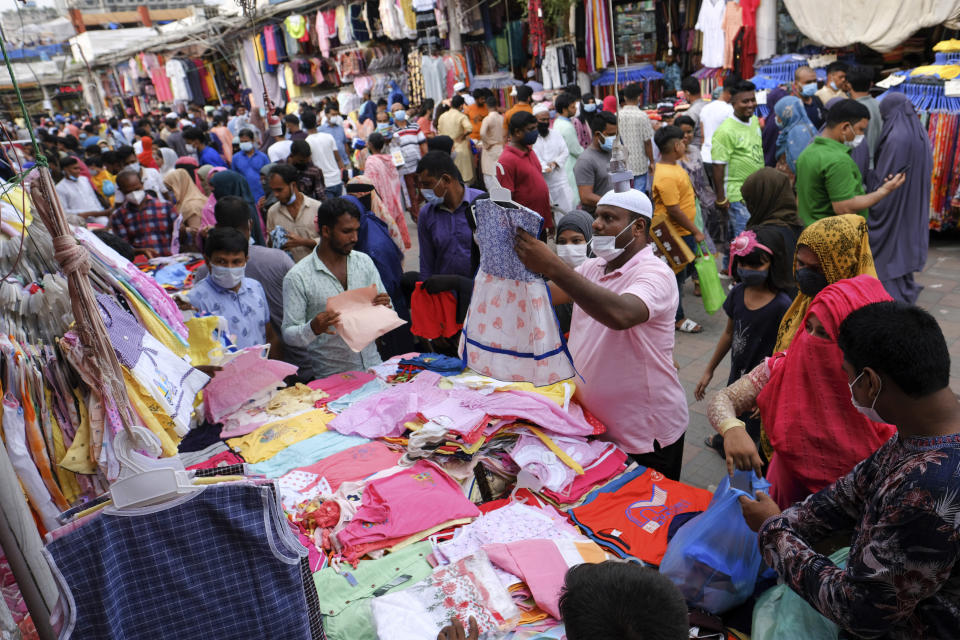 People shop at a market ahead of Eid-al Adha in Dhaka, Bangladesh, Friday, July 16, 2021. Millions of Bangladeshis are shopping and traveling during a controversial eight-day pause in the country’s strict coronavirus lockdown that the government is allowing for the Islamic festival Eid-al Adha. (AP Photo/Mahmud Hossain Opu)