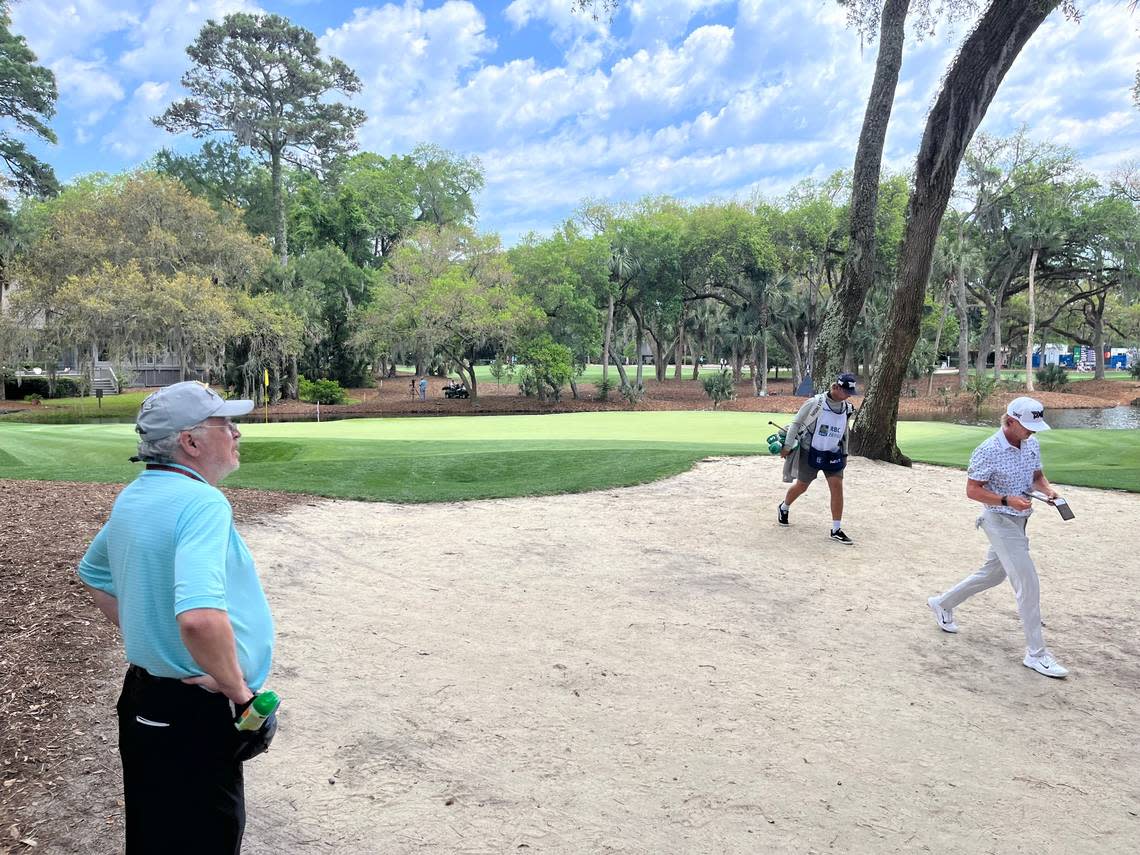 PGA Tour golfer Jake Knapp walks past John Allison, who has worked at the 14th hole in gallery management for 35 years, after completing the 14th hole.