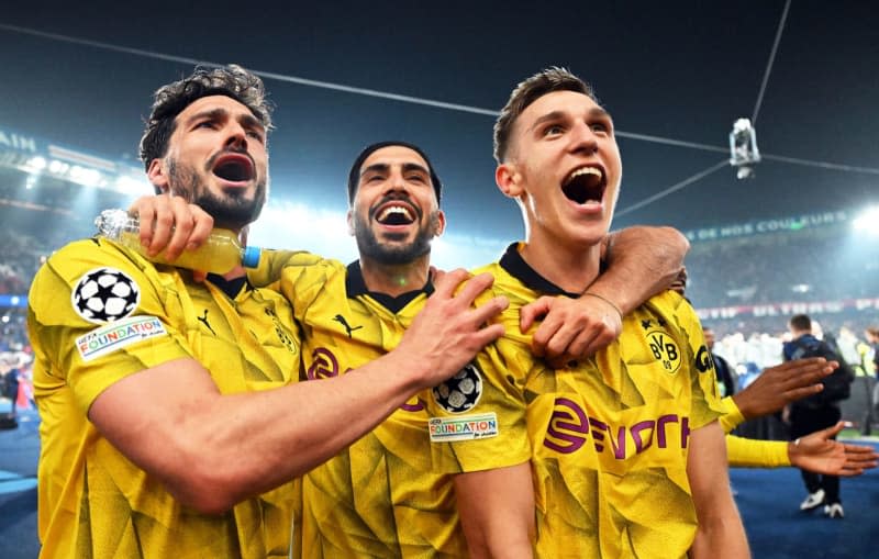 (L-R) Dortmund players Mats Hummels, Emre Can and Nico Schlotterbeck celebrate the victory of the UEFA Champions League semi final against Paris Saint-Germain at the Parc des Princes. Robert Michael/dpa