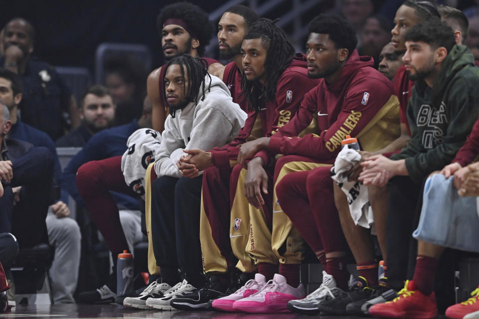 Cleveland Cavaliers guard Darius Garland, front left, sits on the bench during the first half of the team's NBA basketball game against the Utah Jazz, Wednesday, Dec. 20, 2023, in Cleveland. (AP Photo/David Dermer)
