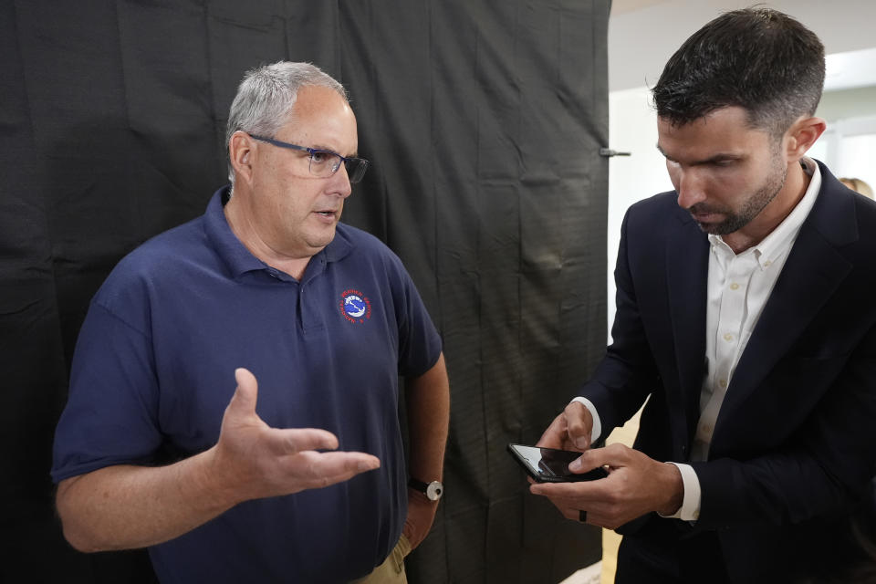 David Hondula, right, Ph.D., Director of Heat Response and Mitigation with the City of Phoenix, listens to Tom Frieders, National Weather Service Warming Coordinator Meteorologist, after a news conference held by the Arizona Department of Health Services and Governor's Office of Resiliency ahead of Heat Awareness Week at the Escalante Multi-Generational Center Friday, May 3, 2024, in Tempe, Ariz. (AP Photo/Ross D. Franklin)