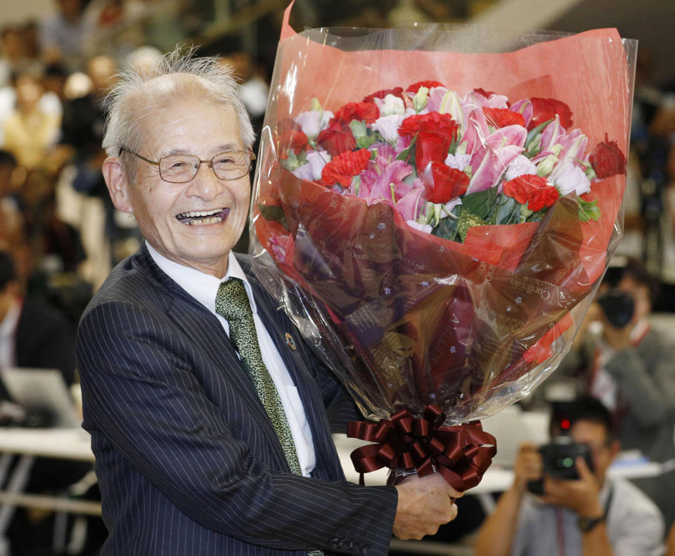 Akira Yoshino of Asahi Kasei Corporation poses with a bouquet of flowers in Tokyo Wednesday, Oct. 9, 2019, following an announcement that he was awarded the Nobel Prize in Chemistry. The prize went to John B. Goodenough of the University of Texas; M. Stanley Whittingham of the State University of New York at Binghamton; and Yoshino. (Yuta Omori/Kyodo News via AP)