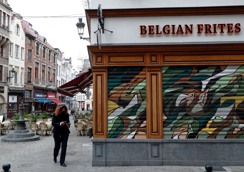 A woman walks past a closed restaurant amid the coronavirus disease outbreak in Brussels