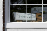 In this Monday, Aug. 5, 2019 photo a model truck sits in a window of the Taunton Daily Gazette newspaper's offices, in Taunton, Mass. The newspaper is published by GateHouse Media New England, a division of GateHouse Media Inc. On Monday, GateHouse Media, a chain backed by an investment firm, announced that it is buying USA Today owner Gannett Co. (AP Photo/Steven Senne)